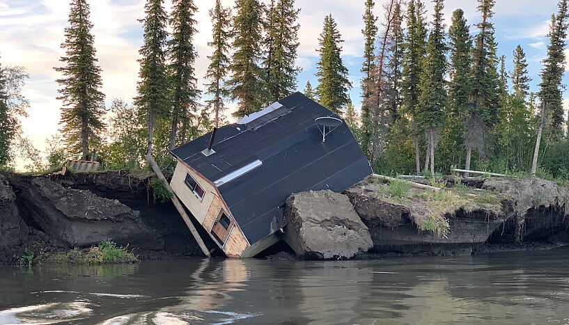 Fig. 1: Picture of a house falling into a river, Mackenzie River Delta, Canada.