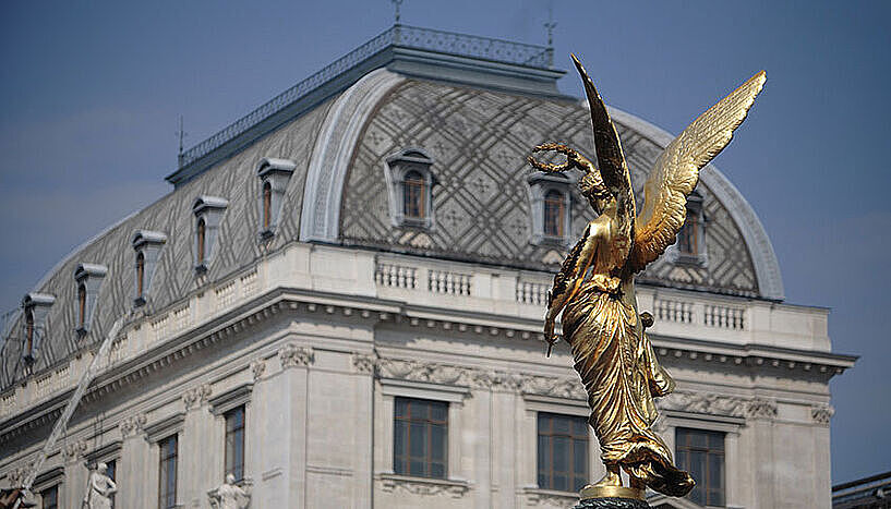 Roof of the University of Vienna with a golden statue in front