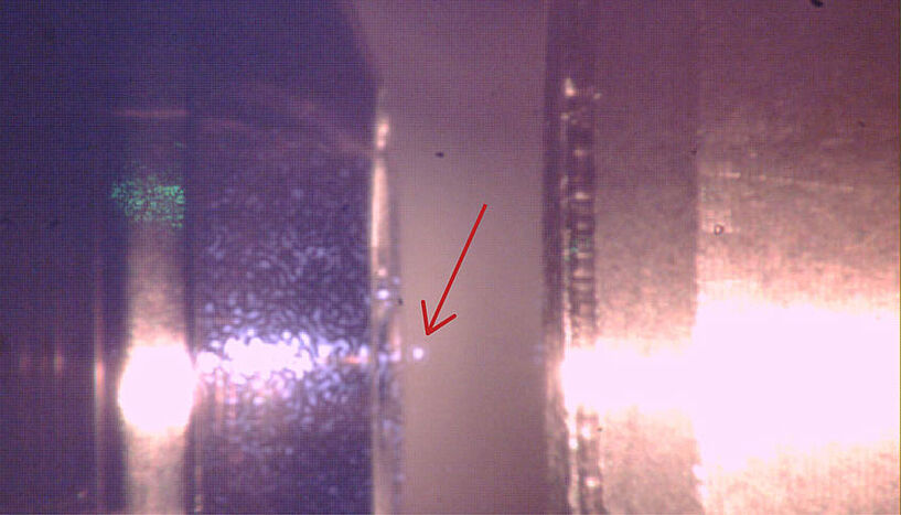 Close up photo of a particle in quantum ground state; only a dot is visible
