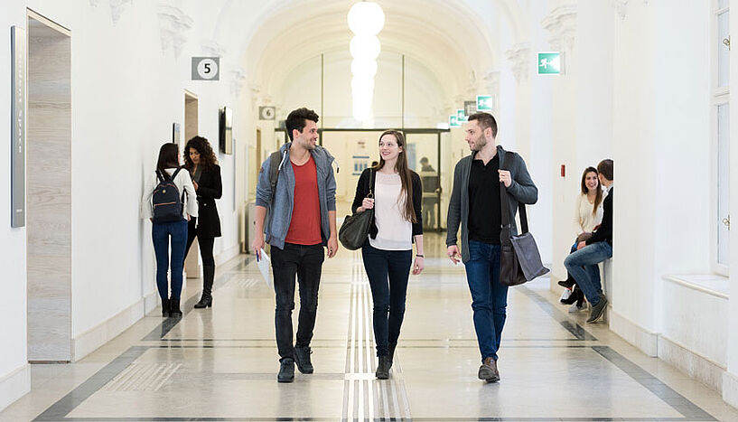Studierende unterhalten sich in einem Gang an der Universität Wien 