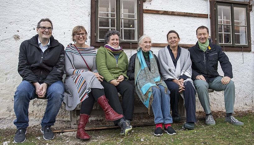 Jane Goodall und Vertreter*innen der Universität Wien sitzen zusammen auf einer Bank