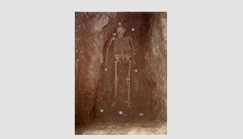 Ein Skelett in einem Grab. 
